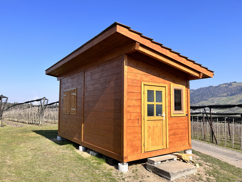 Aussenansicht des hölzernen Bienenhauses mit Eingang und Fenster